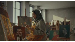 a woman painting in a studio